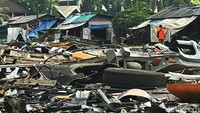 Sejumlah warga melintas di sekitar hamparan rongsokan bus TransJakarta.