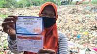 Seorang pengepul sampah menunjukkan surat vaksin usai disuntik Vaksin COVID-19 pada pelaksanaan vaksinasi untuk komunitas pemulung dan pengepul sampah di Tempat Pembuangan Akhir (TPA) Sampah Rawa Kucing, Tangerang, Banten, Selasa (28/9/2021). ANTARA FOTO/Muhammad Iqbal