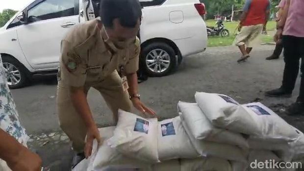 Wali Kota Solo Gibran Rakabuming Raka bagi-bagi beras dengan kemasan berstiker foto dirinya.
