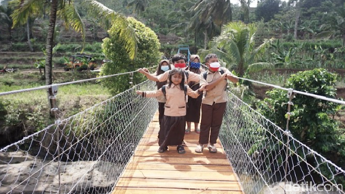 Anak-anak di Sukabumi melintasi jembatan gantung