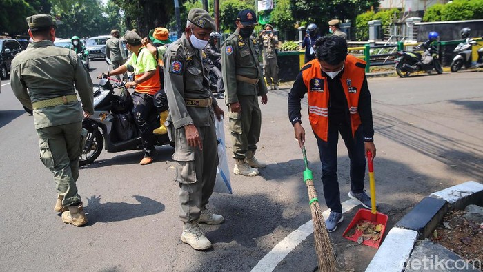 COVID-19 Menurun, Prokes Jangan Kendor Saptol PP gelar razia masker di Jalan Raya Pasar Minggu, Jakarta. Sebanyak 15 pengendara diberhentikan dan mendapatkan sanksi ringan karena tidak memakai masker.