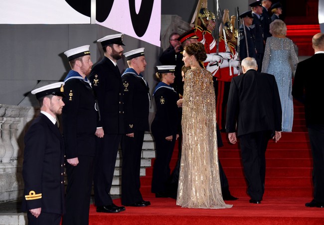 Pilihan busana Kate Middleton untuk No Time To Die boleh dibilang tak terduga mengingat karakter gayanya yang selama ini lebih terkesan kalem dalam palet pastel dan monokromatik. Menurut News.com.au, ia hampir tak pernah memakai busana dengan warna emas yang begitu solid dan berkilau. (Foto: Getty Images for EON Productions)