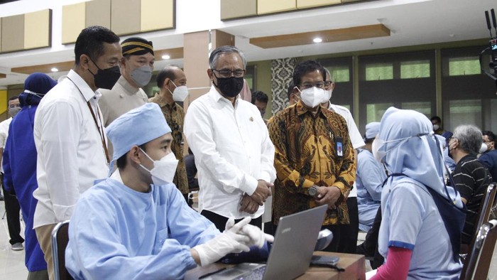 Ketua Dewan Komisioner Otoritas Jasa Keuangan (OJK) Wimboh Santoso (kanan) bersama Wali Kota Solo Gibran Rakabuming Raka (tengah) dan Rektor UNS Jamal Wiwoho (kiri) berdialog virtual dengan Gubernur Jawa Tengah Ganjar Pranowo saat acara Vaksinasi Untuk Negeri di kampus UNS Solo, Jawa Tengah, Kamis (30/9/2021). Ketua OJK Wimboh Santoso berharap kegiatan vaksinasi COVID-19 yang didukung OJK tersebut dapat bermanfaat untuk kesehatan masyarakat guna membangkitkan pertumbuhan ekonomi. ANTARA FOTO/Maulana Surya/hp.