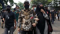 Novel Baswedan menggendeng istrinya Rina Emilda berjalan meninggalkan gedung KPK.