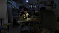 Seorang pria tampak menggunakan senter di ponselnya saat tengah makan di tengah pembatasan pasokan listrik yang terjadi di Provinsi Liaoning, China, Rabu (29/9/2021) waktu setempat.