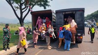 Warga berkumpul terlebih dahulu di kantor desa setempat, baru kemudian dijemput oleh pihak kepolisian dan TNI menggunakan truk.