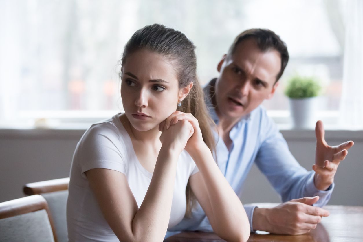 Offended woman sitting back to lover looking away avoiding talking, millennial couple having serious fight, mad man screaming or lecturing wife, stubborn female not ready to compromise or reconcile