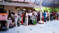 Bocah-bocah berdesakan untuk mengambil makanan yang dibagikan seusai salat Jumat di masjid kawasan Simprug, Jakarta, Jumat (1/10/2021).
