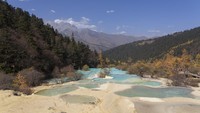 Huanglong Scenic Area dikelilingi oleh pegunungan salju. Ini membuat tempat wisata yang satu ini sangat indah. (Getty Images/iStockphoto)