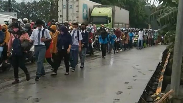 Warga melintas di jalan yang baru dicor di Kabupaten Tangerang. Pengecoran jalan itu belum kering hingga menimbulkan bekas sepatu dan roda (dok.istimewa)