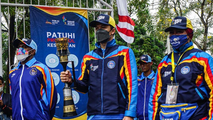 KIRAB API PON PAPUA DI KOTA JAYAPURA Mantan pebulu tangkis Taufik Hidayat (tengah), pesepak bola Boaz Solossa (kiri) dan mantan atlet pencak silat Lilis Karubaba (kanan) membawa api bobor PON Papua saat akan dikirab di kawasan Kantor Wali Kota Jayapura, Papua, Jumat (1/10/2021). Api PON Papua tiba di Kota Jayapura dan dikirab di pusat kota dan akan dilanjutkan menuju Kabupaten Jayapura. ANTARA FOTO/Indrayadi TH/wsj.