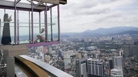 Turis mengambil foto di dek observasi di Menara Kuala Lumpur, Malaysia, Jumat (1/10/2021) waktu setempat.