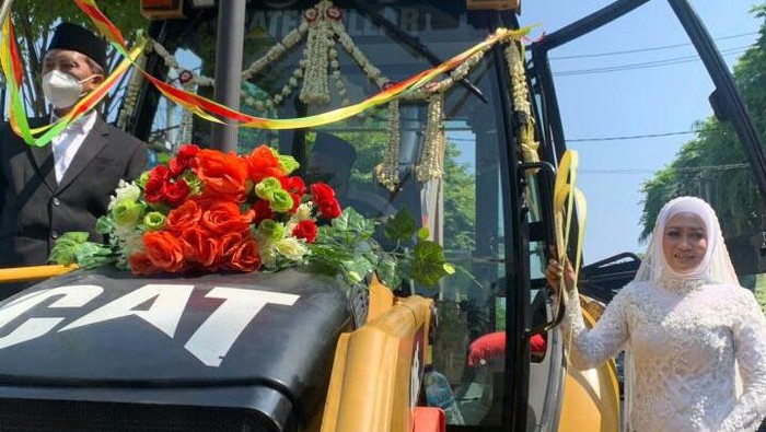 Momen bahagia terjadi di bumi Agkling Darmo. Sepasang pengantin naik alat berat keliling alun-alun kota Bojonegoro dan menjadi tontonan warga dan pengguna jalan.