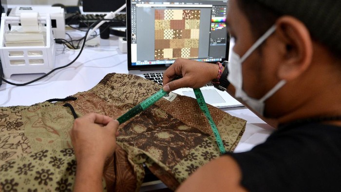 Calon pembeli mencoba produk pakaian batik bernuansa kasual di Denpasar, Bali, Jumat (1/10/2021). Berbagai jenis pakaian batik seperti kaos, jaket dan kemeja yang dibuat dengan teknik printing sablon tersebut diproduksi Voordurend Love Bali dengan nuansa desain dan model kekinian untuk menyambut Hari Batik Nasional guna melestarikan pemakaian busana batik bagi generasi muda. ANTARA FOTO/Fikri Yusuf/rwa.