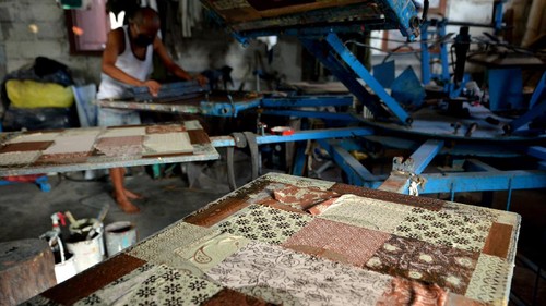 Calon pembeli mencoba produk pakaian batik bernuansa kasual di Denpasar, Bali, Jumat (1/10/2021). Berbagai jenis pakaian batik seperti kaos, jaket dan kemeja yang dibuat dengan teknik printing sablon tersebut diproduksi Voordurend Love Bali dengan nuansa desain dan model kekinian untuk menyambut Hari Batik Nasional guna melestarikan pemakaian busana batik bagi generasi muda. ANTARA FOTO/Fikri Yusuf/rwa.