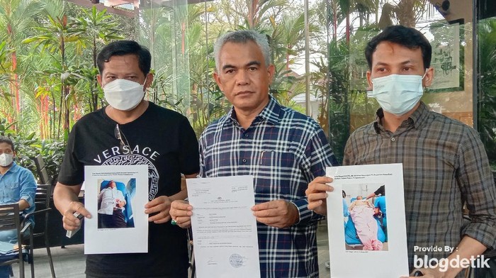 Pengacara PT Propernas Nusa Dua, Sastra (tengah), bersama keluarga korban menunjukkan foto kedua korban usai ditusuk OTK.