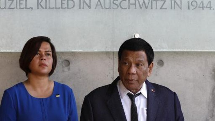 The President of the Philippines Rodrigo Duterte looks on as he signs the guest book next to his daughter (L) on September 3, 2018 during his visit to the Yad Vashem Holocaust Memorial museum in Jerusalem commemorating the six million Jews killed by the German Nazis and their collaborators during World War II. (Photo by GALI TIBBON / AFP)