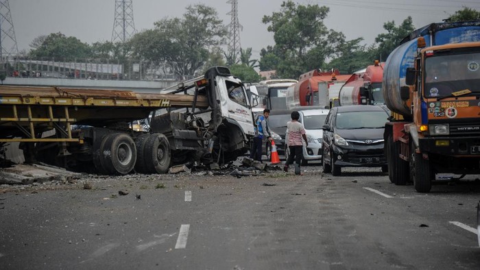 KECELAKAAN DI TOL PURBALEUNYI Petugas Jasa Marga memotret kondisi truk yang mengalami kecelakaan di kilometer 134 Jalan Tol Purbaleunyi di Pasir Koja, Bandung, Jawa Barat, Minggu (3/10/2021). Kecelakaan yang melibatkan sebuah truk pengangkut tiang bor, sebuah travel dan sebuah mobil keluarga tersebut masih dalam penyelidikan petugas. ANTARA FOTO/Raisan Al Farisi/rwa.