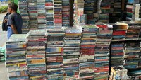 Seorang pedagang buku bekas menanti pengunjung.
