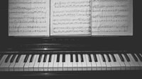 Partitur terpasang di atas piano. Jari-jari keriput masih fasih melantunkan melodi. Namun, tatapan mata sayu seakan membawa Pak Guru melintasi waktu yang paling terpuruk dalam hidupnya.   