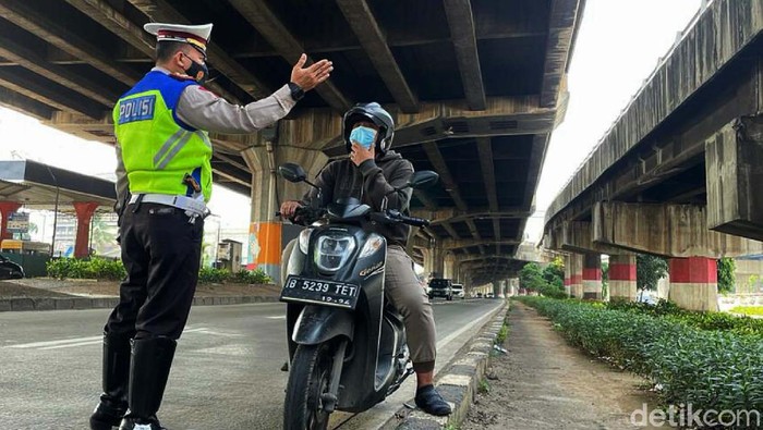 Priiit! Masuk Jalur Cepat, Pemotor Ditilang Sejumlah pemotor ditilang petugas kepolisian di Jalan DI Panjaitan, Jakarta Timur, Minggu (3/10). Mereka kedapatan melintas di jalur cepat.
