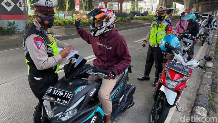 Priiit! Masuk Jalur Cepat, Pemotor Ditilang Sejumlah pemotor ditilang petugas kepolisian di Jalan DI Panjaitan, Jakarta Timur, Minggu (3/10). Mereka kedapatan melintas di jalur cepat.