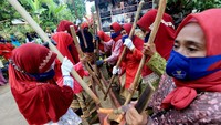 Ibu-ibu Desa Wisata Cikolelet tampak menumbuk beras.