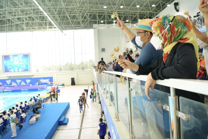 Sepanjang pertandingan, Kang Emil bersama kontingen PON Jabar lainnya terus membunyikan alat tradisional bambu untuk memberikan semangat kepada Tim Polo Air Putra Jabar dari tribun penonton.
