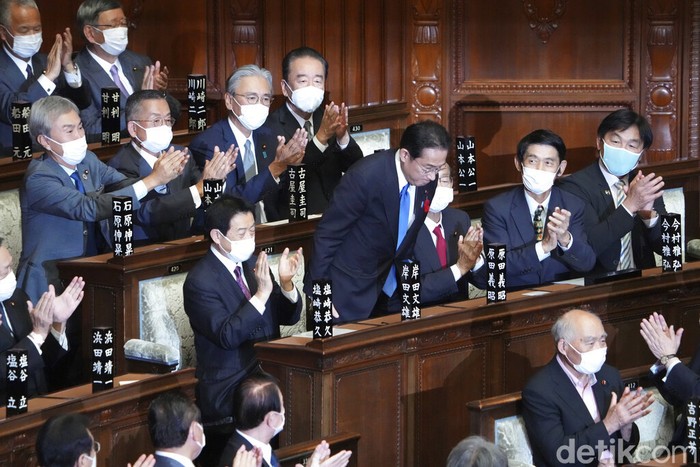 Fumio Kishida, center, is applauded after being named as Japan's prime minister at the parliament's lower house in Tokyo Monday, Oct. 4, 2021. Kishida was elected Japan's prime minister in a parliamentary vote Monday and will be tasked with quickly tackling the pandemic and other domestic and global challenges and leading a national election within weeks. (Kyodo News via AP)