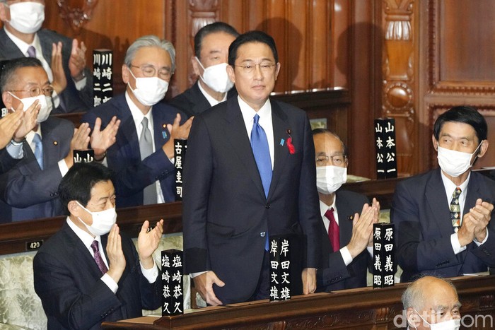 Fumio Kishida, center, is applauded after being named as Japan's prime minister at the parliament's lower house in Tokyo Monday, Oct. 4, 2021. Kishida was elected Japan's prime minister in a parliamentary vote Monday and will be tasked with quickly tackling the pandemic and other domestic and global challenges and leading a national election within weeks. (Kyodo News via AP)