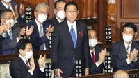 Fumio Kishida berdiri saat memperoleh tepuk tangan dari anggota parlemen, usai terpilih sebagai PM Jepang, di Tokyo, Senin  (4/10/2021). (Kyodo News via AP)