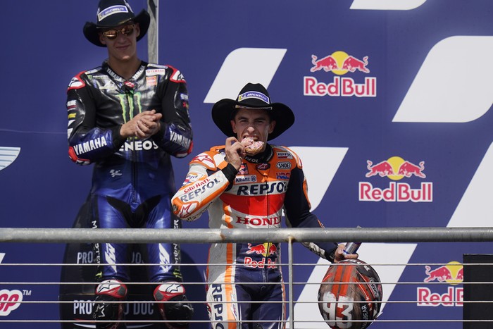 Marc Marquez Juara MotoGP AS 2021 Spain's Marc Marquez, right, eats a doughnut as he celebrates his win at the MotoGP Grand Prix of the Americas motorcycle race at Circuit of the Americas, Sunday, Oct. 3, 2021, in Austin, Texas. (AP Photo/Eric Gay)