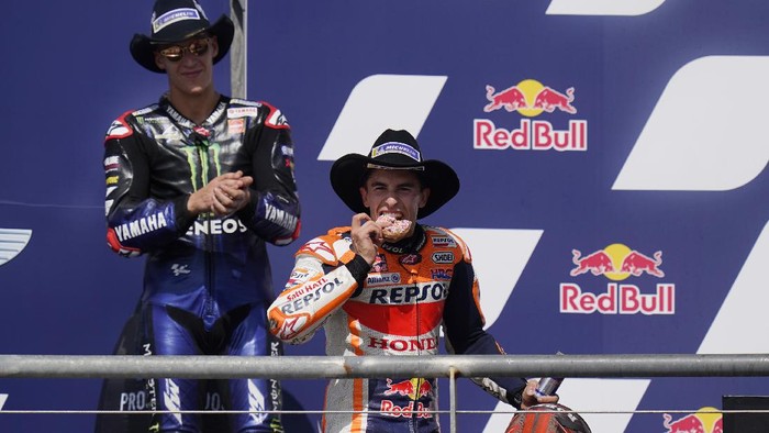 Marc Marquez Juara MotoGP AS 2021 Spain's Marc Marquez, right, eats a doughnut as he celebrates his win at the MotoGP Grand Prix of the Americas motorcycle race at Circuit of the Americas, Sunday, Oct. 3, 2021, in Austin, Texas. (AP Photo/Eric Gay)
