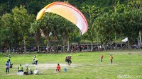 Warga tinggal memarkir kendaraan di tepi jalan dan nonton buaya sekaligus menyaksikan para atlet paralayang unjuk kebolehan di PON Papua. (Femi Diah/detikcom)