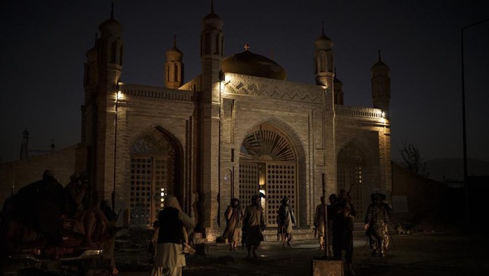 Taliban fighters walk at the entrance of the Eidgah Mosque after an explosion in Kabul, Afghanistan, Sunday, Oct. 3, 2021. A bomb exploded in the entrance of the mosque in the Afghan capital on Sunday leaving a 