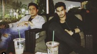 Santai sambil minum kopi jadi pilihan Tengku Tezi. Ia pun tak lewatkan berpose bareng temannya.