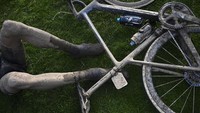 Cipratan lumpur memenuhi seluruh badan dan sepeda. Balapan klasik Paris-Roubaix sempat tidak digelar pada tahun 2020 karena wabah global Covid-19. Selain wabah, sejarah balapan yang sudah digelar lebih dari satu abad ini sempat terhenti karena perang dunia. (Anne-Christine Poujoulat/Pool Photo via AP)