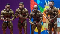 Atlet binaraga Papua Cornelius Amo (dua kanan) memperagakan salah satu gerakan tubuh dalam pertandingan binaraga kelas 60 kilogram PON Papua di Auditorium Universitas Cenderawasih, Jayapura, Papua, Senin (4/10/2021).   