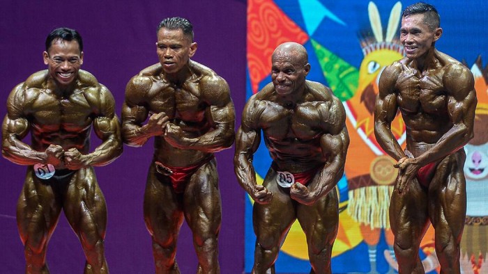 Atlet binaraga Papua Cornelius Amo (dua kanan) memperagakan salah satu gerakan tubuh dalam pertandingan binaraga kelas 60 kilogram PON Papua di Auditorium Universitas Cenderawasih, Jayapura, Papua, Senin (4/10/2021). Cornelius Amo meraih medali emas, medali perak diraih atlet binaraga Sulawesi Tengah Jefry Johanis Wuaten, dan medali perunggu diraih DKI Jakarta Slamet Junaidi. ANTARA FOTO/Indrayadi TH/tom.