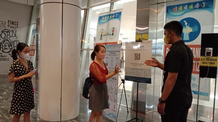 FOTO: Para pengunjung diarahkan untuk melakukan scan QRcode aplikasi Peduli Lindungi. (Trisno Mais)
