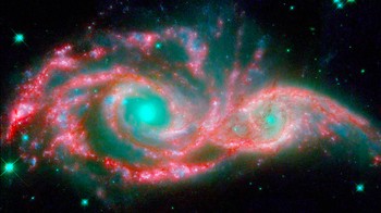 Mata langit hijau ini sebenarnya inti dari dua galaksi yang menyatu, yaitu NGC 2207 dan IC 2163, galaksi ini dikelilingi lengan spiral. Foto: NASA