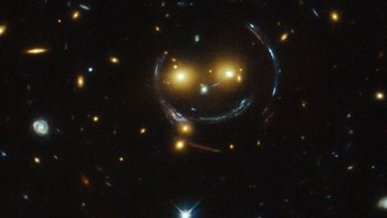 Gambar galaksi bermacam-macam, tak hanya menyerupai mata. Ada juga yang mirip mimik wajah yang tengah tersenyum seperti klaster galaksi bernama SDSS J1038+4849 ini. Foto: NASA