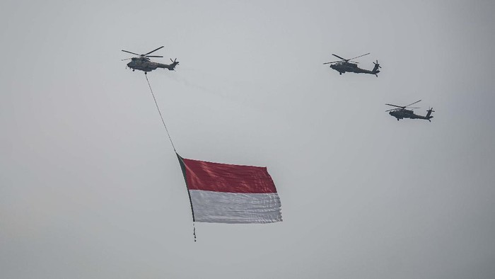 Tujuh helikopter TNI terbang dengan mengibarkan bendera Merah Putih dan Lambang TNI di kawasan Monas, Jakarta, Selasa (5/10/2021). Dalam rangka peringatan HUT Ke-76 Tentara Nasional Indonesia (TNI), sebanyak delapan pesawat helikopter TNI (AD, AL, AU) dengan call sign 