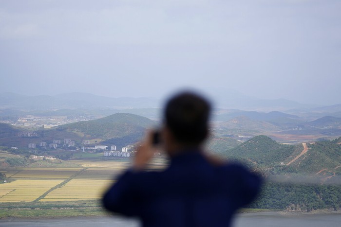 A visitor uses a smartphone to film the North Koreas Kaepoong from the observatory of the Aegibong Peace Ecopark in Gimpo, South Korea, Tuesday, Oct. 5, 2021. (AP Photo/Lee Jin-man)