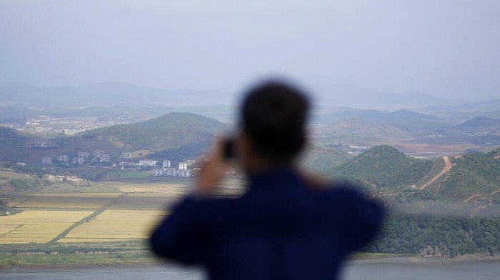 A visitor uses a smartphone to film the North Korea's Kaepoong from the observatory of the Aegibong Peace Ecopark in Gimpo, South Korea, Tuesday, Oct. 5, 2021. (AP Photo/Lee Jin-man)