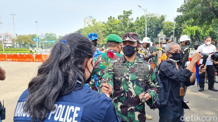 Polwan bagi-bagi bunga ke prajurit TNI saat HUT TNI ke-76 di Monas