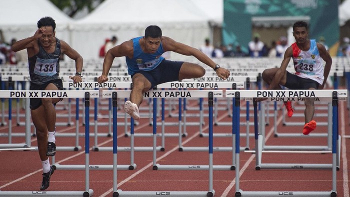 Pelari Sumatera Selatan Rio Maholtra (tengah) berlari paling depan dalam final nomor lari 110 meter gawang putra cabang atletik PON Papua di Stadion Atletik Mimika Sport Center, Kabupaten Mimika, Papua, Selasa (5/10/2021). Rio meraih medali emas, sementara pelari Riau Hirzan Rahmadon meraih medali perak dan pelari Jawa Timur Ghanes Bagus Pandega meraih medali perunggu. ANTARA FOTO/Aditya Pradana Putra/tom.