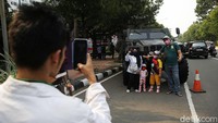 Sejumlah warga berfoto di depan kendaraan perang yang dipamerkan dalam rangka HUT ke-76 TNI di depan Istana Merdeka, Jakarta, Selasa (5/10/2021).