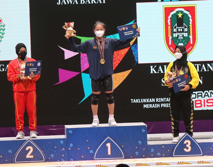 Lifter putri Jawa Barat, Cantika A Windy  (tengah) pemenang medali emas kelas 49 kg total angkatan 192kg dan Jawa Tengah, Nafisatul H.Siti (kiri) medali perak total angkatan 170 kg serta  Kalimantan Selatan, Amanda Riska Nur (kanan) medali perunggu dengan total angkatan 167 kg cabor angkat besi  putri PON XX Papua di Auditorium Universitas Cendrawasih Jayapura, Rabu 6/10/2021.Foto: PB PON XX PAPUA/Dadang Tri