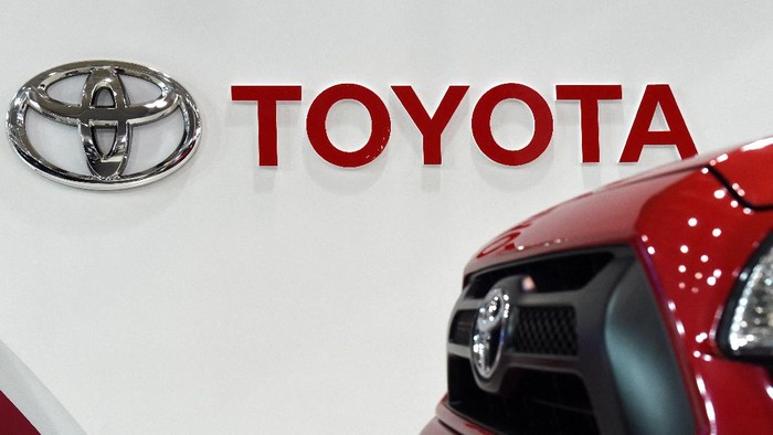 The Toyota logo is displayed beside a pick-up truck on display at a Toyota showroom in Tokyo on February 4, 2016.          AFP PHOTO / TOSHIFUMI KITAMURA (Photo by TOSHIFUMI KITAMURA / AFP)